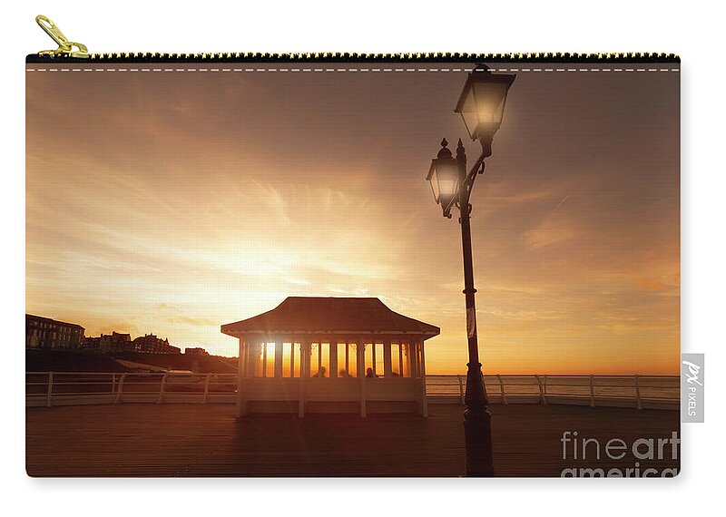 Norfolk Zip Pouch featuring the photograph Cromer pier in Norfolk England shelter at sunset by Simon Bratt