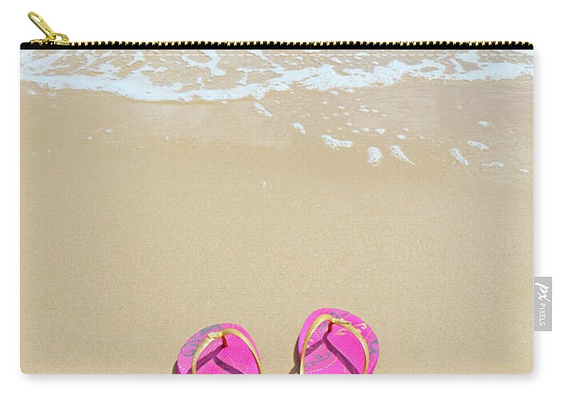 Water's Edge Zip Pouch featuring the photograph Flip Flops On A Sandy Beach by Kathy Collins