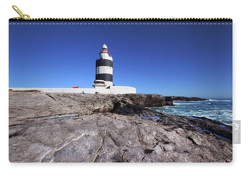 Water's Edge Zip Pouch featuring the photograph Hook Head Lighthouse In Ireland by Stevegeer