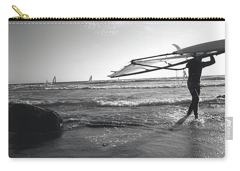 Photography Zip Pouch featuring the photograph Man Carrying A Surfboard Over His Head by Panoramic Images