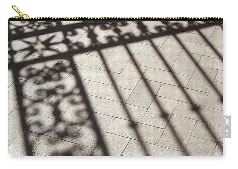 Hand Raised Zip Pouch featuring the photograph Mans Shadows Near Ornate Iron Fence by Grant Faint