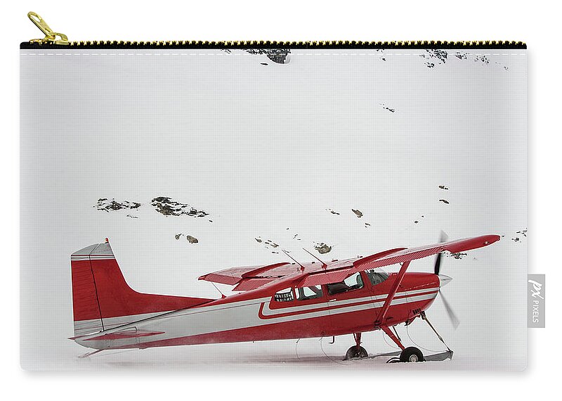 Tranquility Zip Pouch featuring the photograph Red Plane With Skis Taking Off In Snow by Robin Skjoldborg