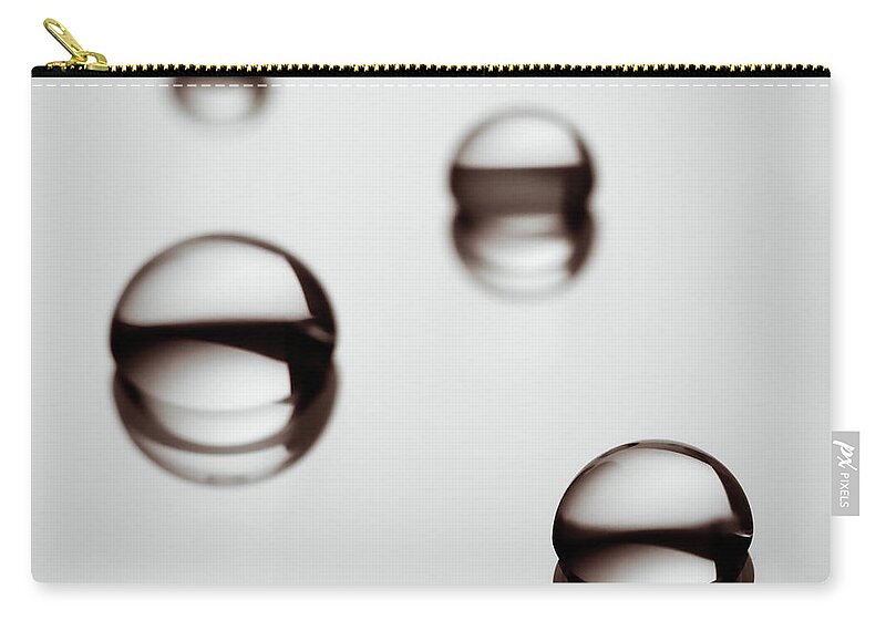 Purity Zip Pouch featuring the photograph Water Droplets On A Reflective Surface by Vilhjalmur Ingi Vilhjalmsson