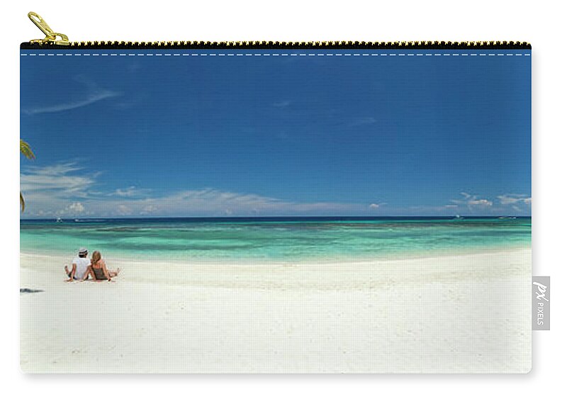 Young Men Zip Pouch featuring the photograph Young Couple Relaxing On Beach by Dstephens