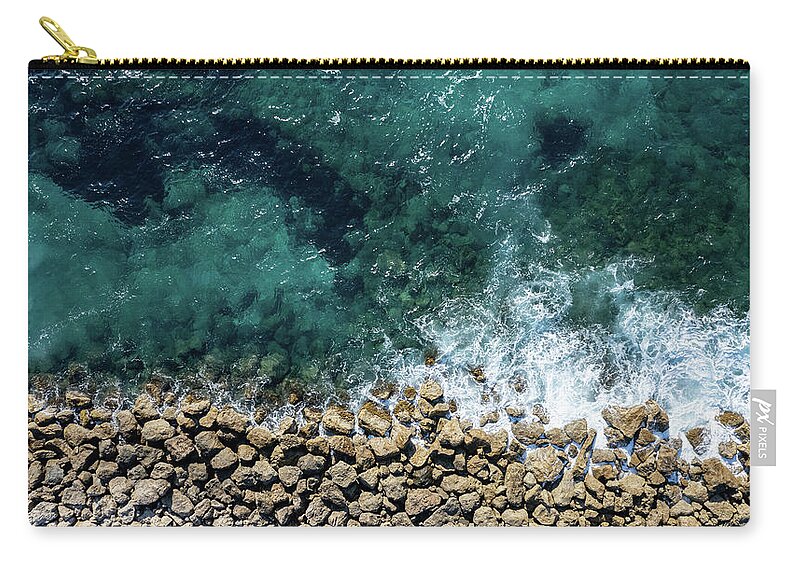 Seascape Carry-all Pouch featuring the photograph Aerial view from flying drone of crystal blue ocean water and sea wall. by Michalakis Ppalis