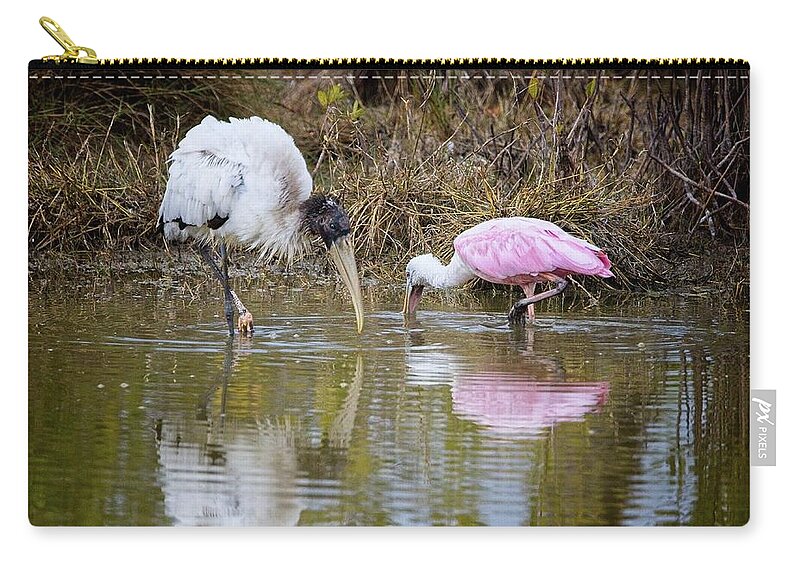 Feeding Zip Pouch featuring the photograph A Wood Stork and Spoonbill feeding together. by Ronald Lutz