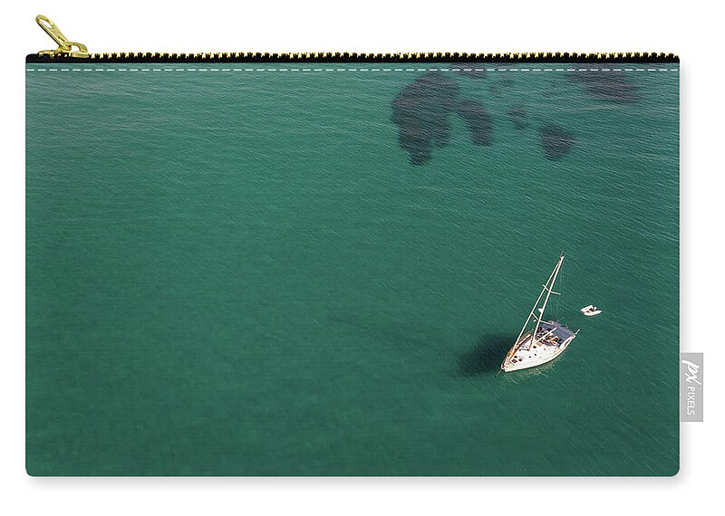 Anchored Carry-all Pouch featuring the photograph Aerial view of a luxury yacht anchored in the surface of the sea. Cyprus vacations by Michalakis Ppalis