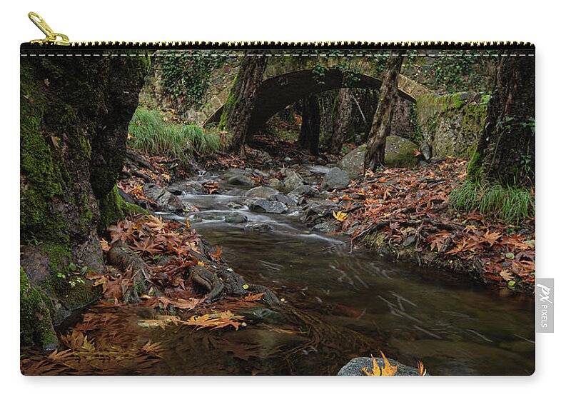 Autumn Zip Pouch featuring the photograph Autumn landscape with river flowing below a stoned ancient bridge by Michalakis Ppalis