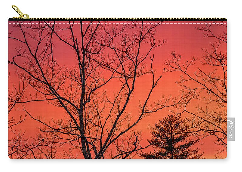 New Hampshire Zip Pouch featuring the photograph Bare Trees And Sky Afire. by Jeff Sinon