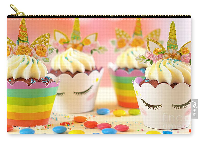 Cupcake Zip Pouch featuring the photograph Decorating children's birthday party unicorn themed cupcakes, closeup. by Milleflore Images