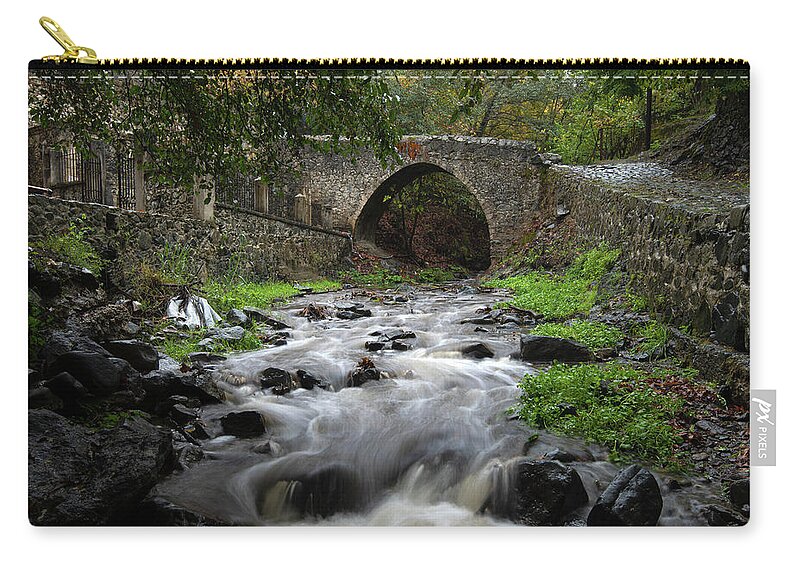 River Carry-all Pouch featuring the photograph Medieval stoned bridge water flowing in the river. by Michalakis Ppalis