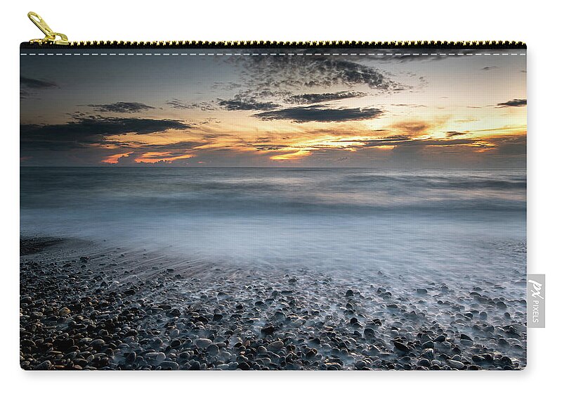 Seascape Zip Pouch featuring the photograph Seawaves splashing on the coast during a dramatic sunset by Michalakis Ppalis