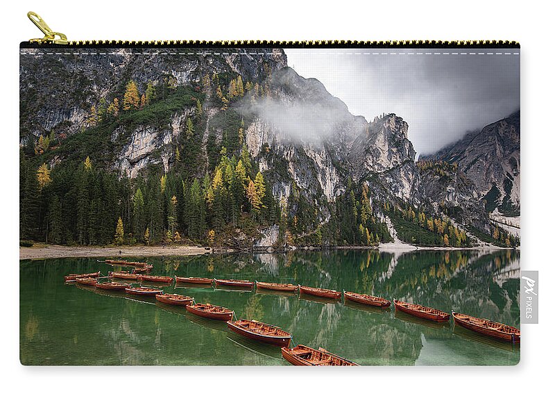 Lago Di Braies Carry-all Pouch featuring the photograph Wooden boats on the peaceful lake. Lago di braies, Italy by Michalakis Ppalis