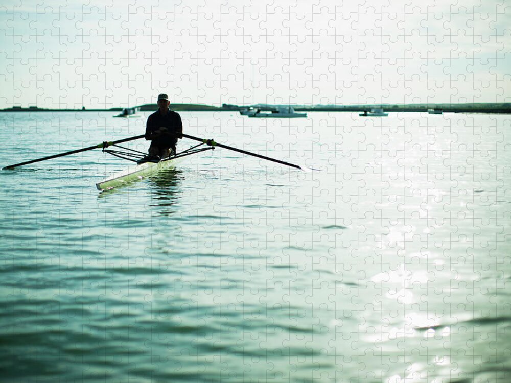 People Jigsaw Puzzle featuring the photograph A Mature Man In A Rowing Boat On The by Mint Images/ Jamie Kripke