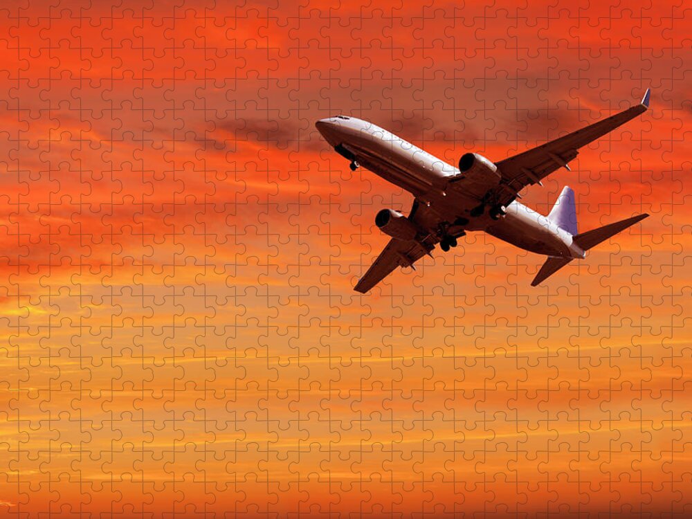 Outdoors Jigsaw Puzzle featuring the photograph Airplane Flying In Red Sky At Sunset by Buena Vista Images