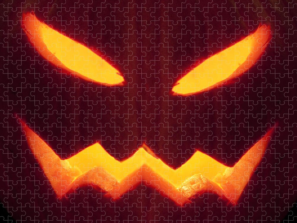 Pumpkin; Glow; Glowing; Dark; Darkness; Jack O Lantern; Horror; Haunting; Haunted; Haunt; Ghoul; Frightening; Moody; Scary; Fright; Eerie; Foreboding; Shadow; Night; Ominous; Evil Fear; Foreboding; Seasonal; Halloween; Carved; Close Up; Eyes; Mouth Jigsaw Puzzle featuring the photograph Glowing Pumpkin by Margie Hurwich