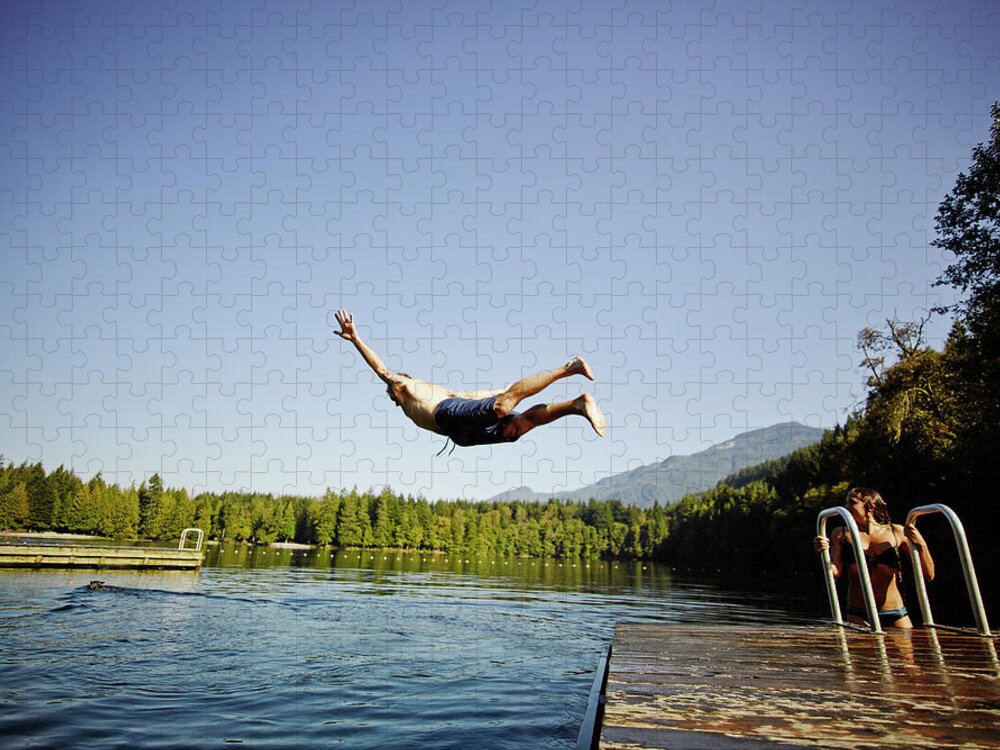 Tranquility Jigsaw Puzzle featuring the photograph Man Diving Off Dock Into Mountain Lake by Thomas Barwick