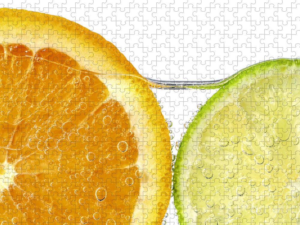 Orange Jigsaw Puzzle featuring the photograph Orange and lime slices in water by Elena Elisseeva