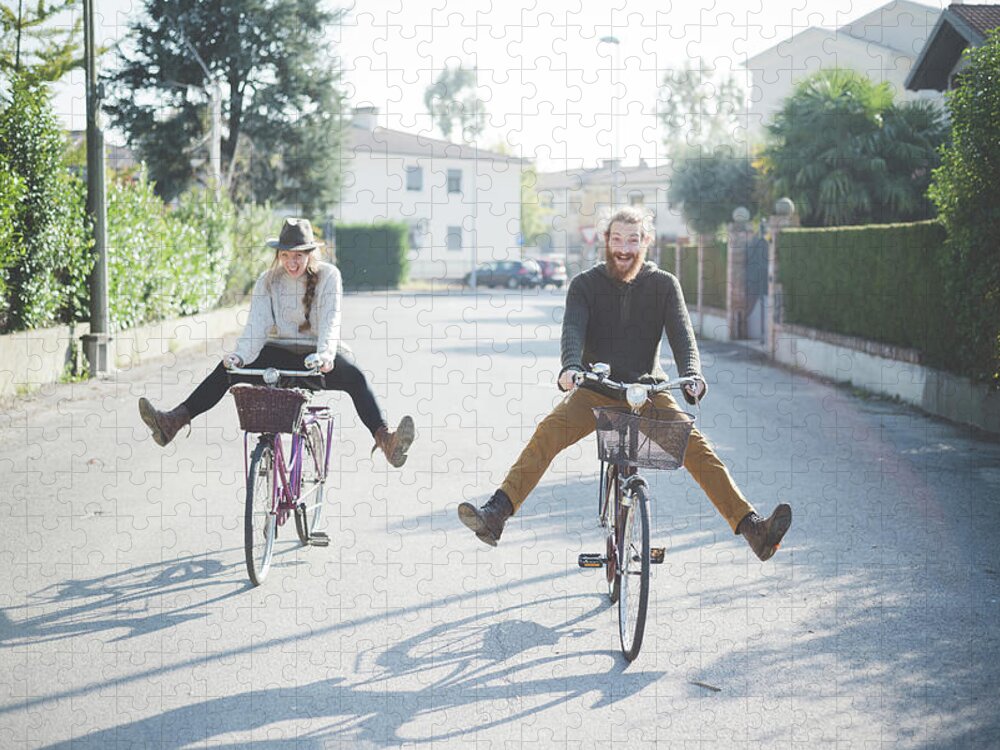 Young Men Jigsaw Puzzle featuring the photograph Young Couple Cycling With Legs Out by Eugenio Marongiu