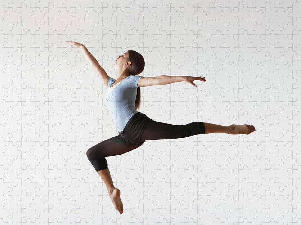 Ballet Dancer Jigsaw Puzzle featuring the photograph Ballerina Leaping In Mid-air by Moodboard