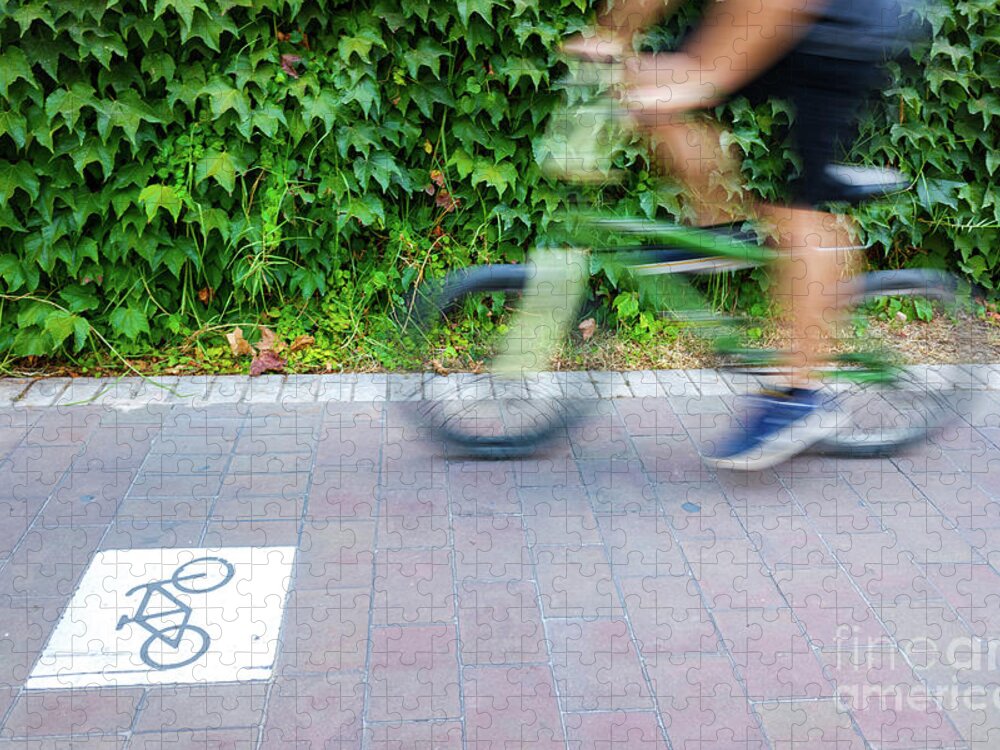 Action Jigsaw Puzzle featuring the photograph Motion blurred cyclists to show speed, driving along a bike lane by Joaquin Corbalan