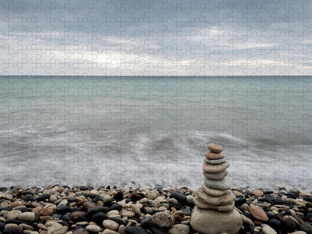 Sea And Ocean Jigsaw Puzzle featuring the photograph Pyramid of balancing stones , in the wavy ocean by Michalakis Ppalis