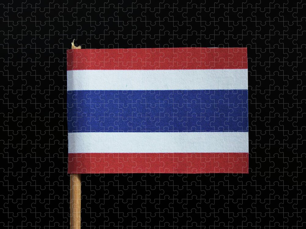 The national flag of the Kingdom of Thailand on toothpick on black background. Five horizontal stripes of red, white, blue, white and red, the middle stripe as wide as the others