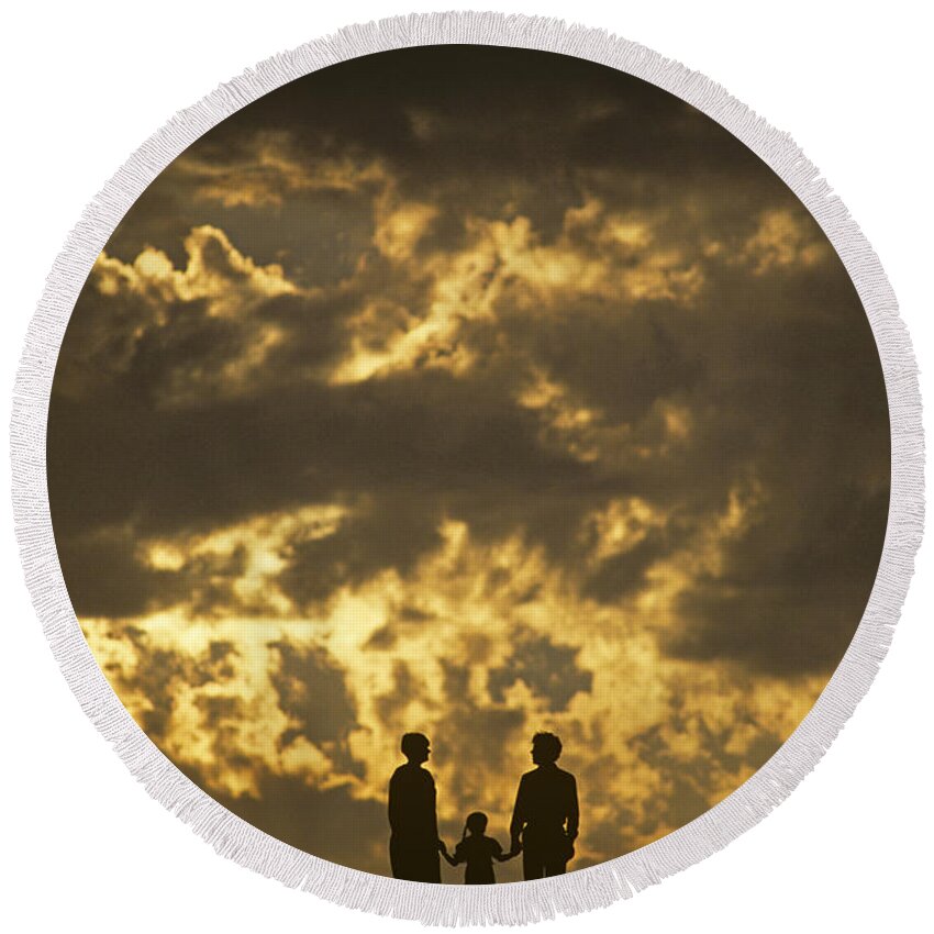 Silhouetted Round Beach Towel featuring the photograph Family on hillside holding hands and facing life together. by Jim Corwin