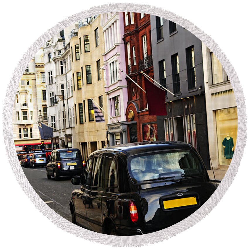 London Round Beach Towel featuring the photograph London taxi on shopping street by Elena Elisseeva
