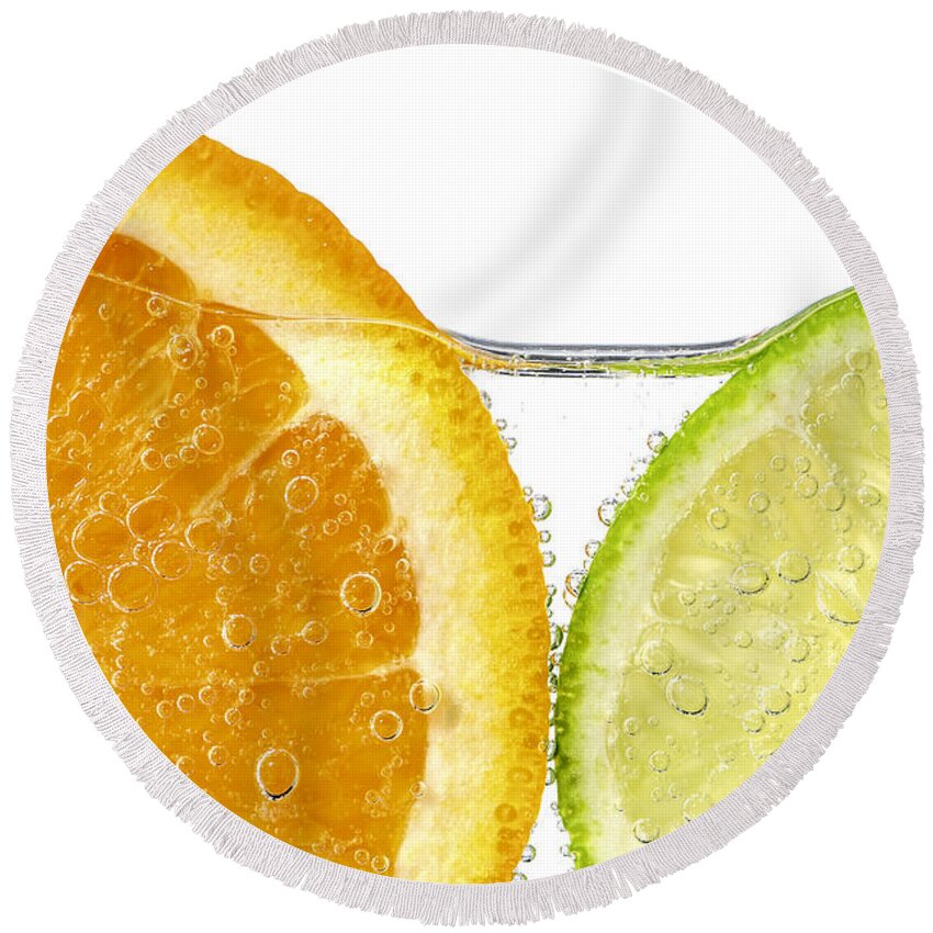 Orange Round Beach Towel featuring the photograph Orange and lime slices in water by Elena Elisseeva