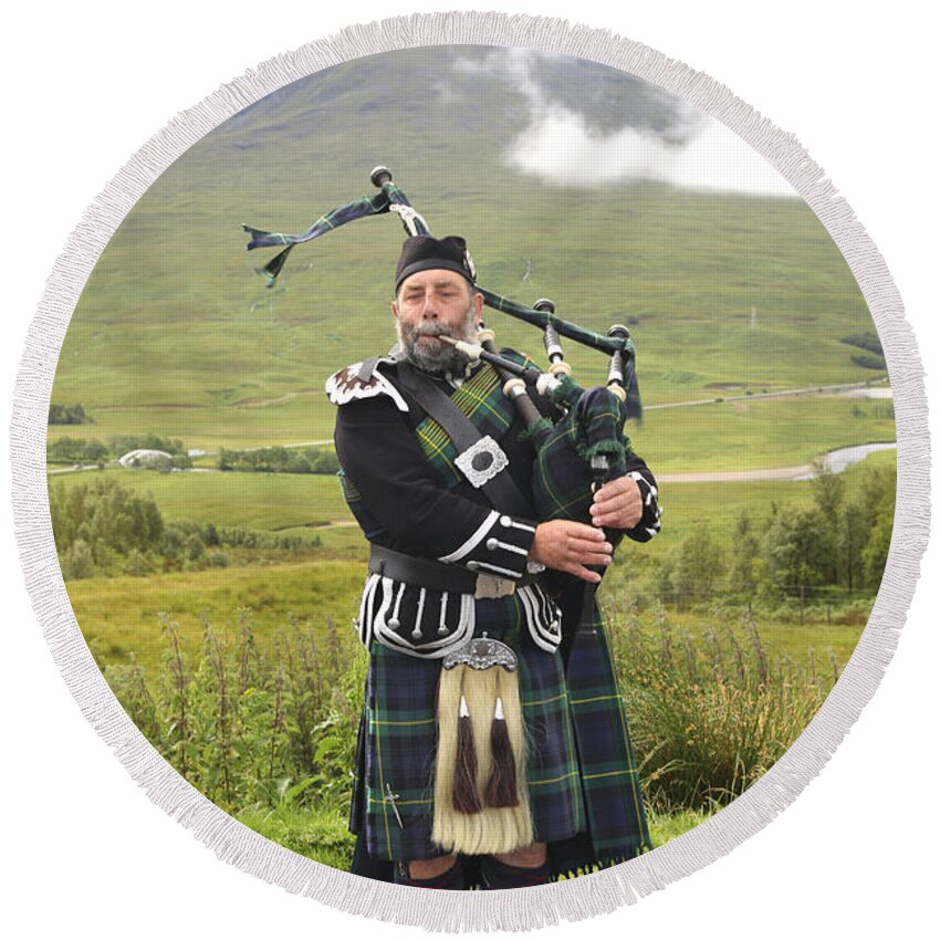 Bagpipe Round Beach Towel featuring the photograph Playing bagpiper in Highlands by Patricia Hofmeester
