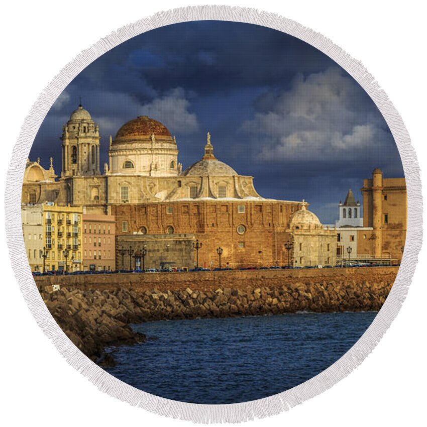 Andalucia Round Beach Towel featuring the photograph Stormy Skies Over the Cathedral Cadiz spain by Pablo Avanzini