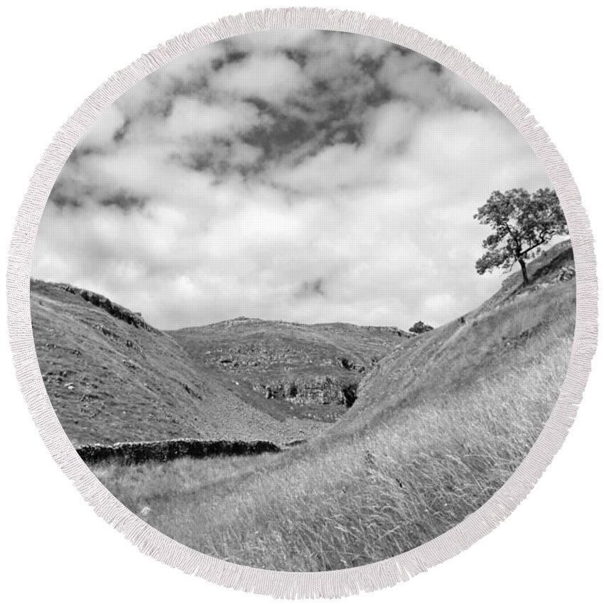 Yorkshire Dales Dramatic British English England Britain Landscape Countryside Hills Uk United Kingdom Tree Slope Dry Stone Wall Scenic Scenery Lone Single Atmospheric Mono Black And White Round Beach Towel featuring the photograph Lone tree in the Yorkshire Dales by Julia Gavin