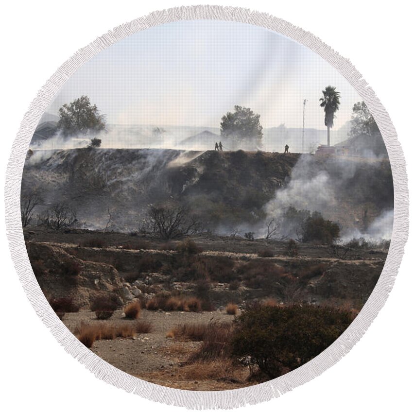 Remnants Of A Large Fire Round Beach Towel featuring the photograph Remnants of a large fire by Nina Prommer