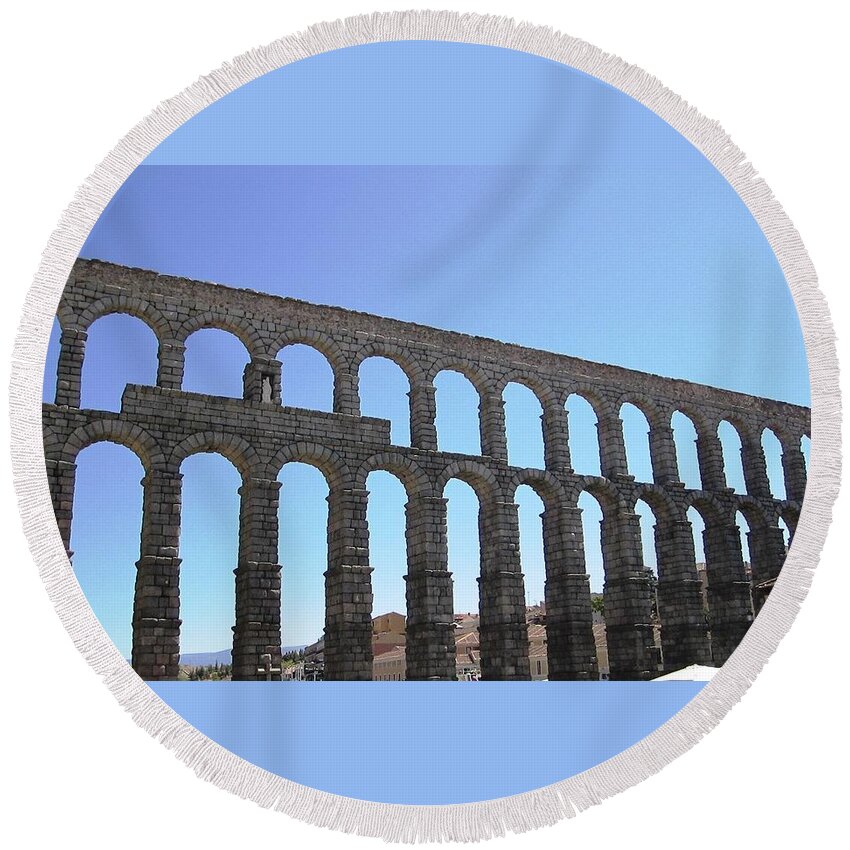Segovia Round Beach Towel featuring the photograph Segovia Ancient Roman Aqueduct Architectural Granite Stone Structure IX With Arches in Sky Spain by John Shiron