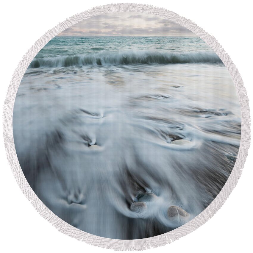 Coastline Round Beach Towel featuring the photograph Pebbles in the beach and flowing sea water by Michalakis Ppalis