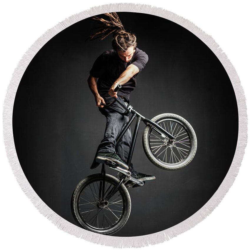 Man Round Beach Towel featuring the photograph A man doing an extreme stunt on his BMX bicycle. by Michal Bednarek