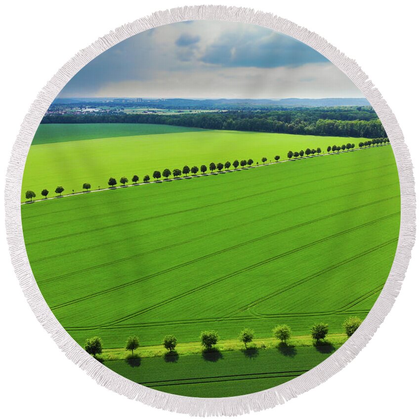 Green Round Beach Towel featuring the photograph Bright green landscape with fields and trees by Matthias Hauser