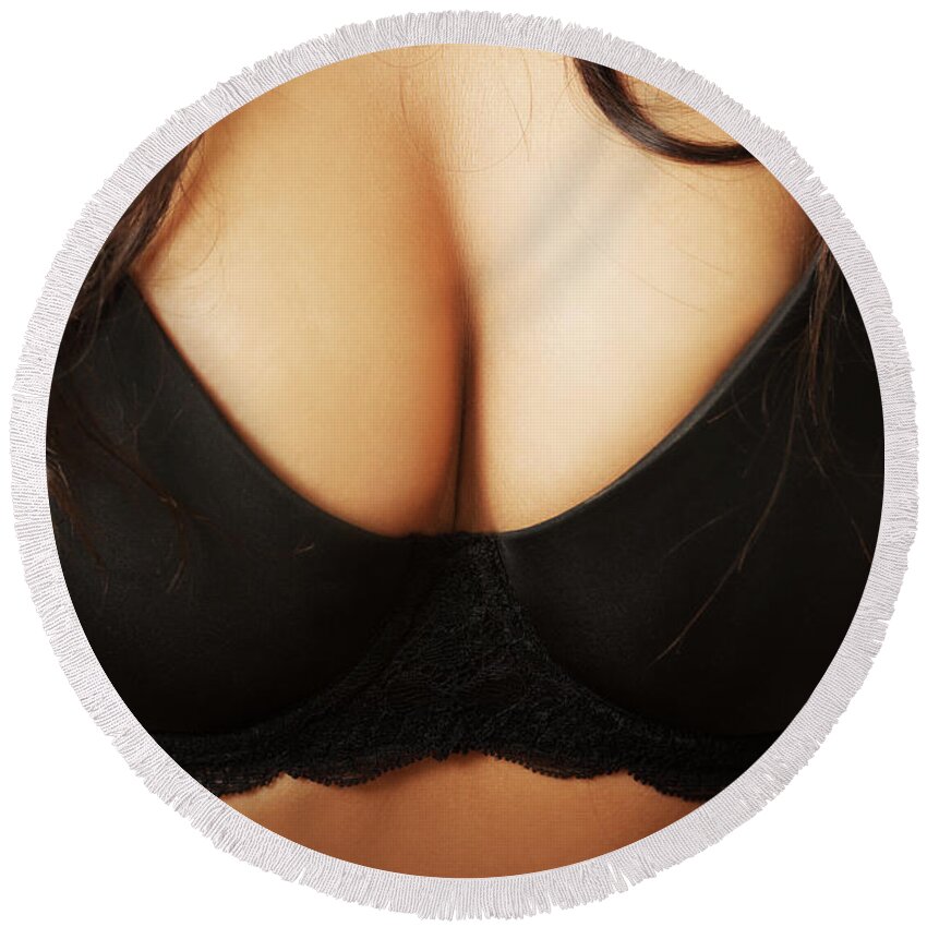 Close up on female boobs in black bra Round Beach Towel