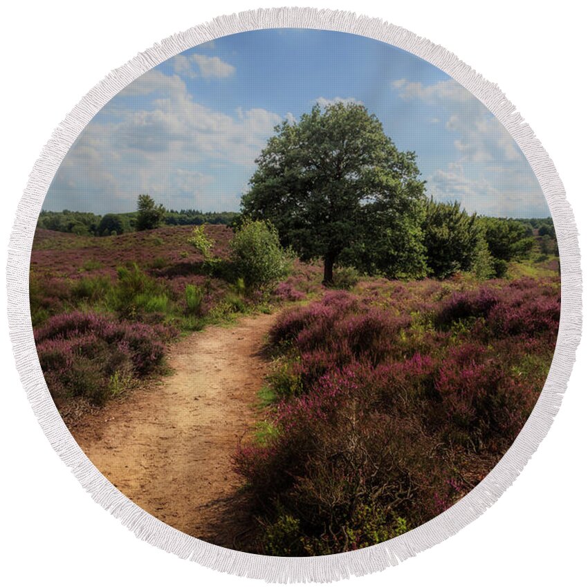 Beautiful Round Beach Towel featuring the photograph Heath landscape with purple heather flowers by Tim Abeln