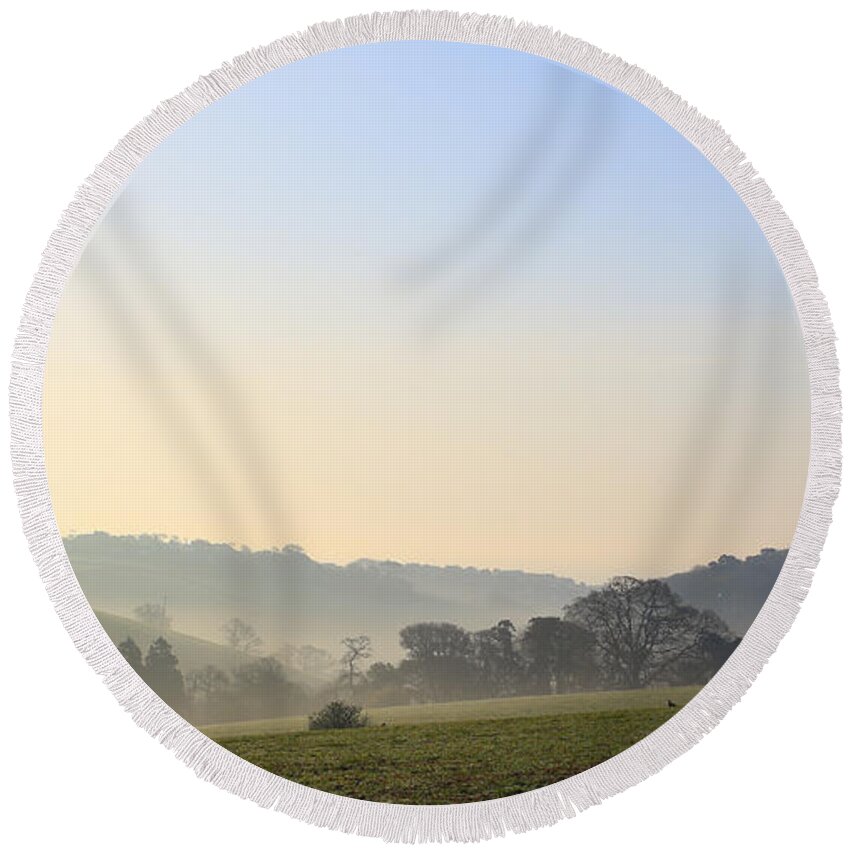 Misty Round Beach Towel featuring the photograph Misty dawn over the Cornish countryside by Tony Mills