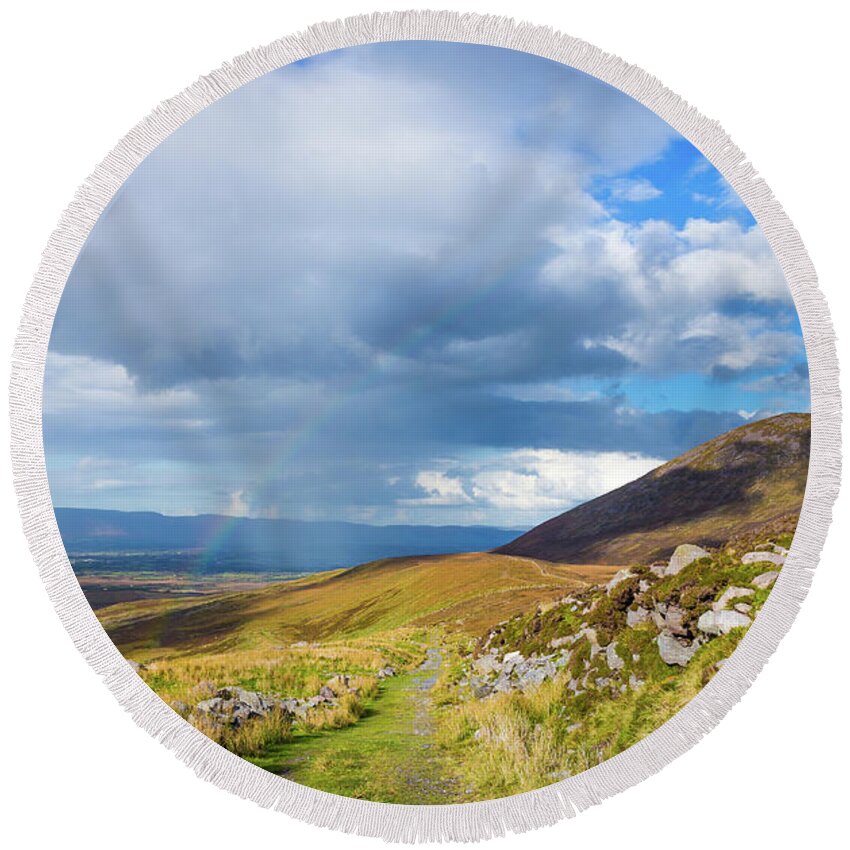 Blue Round Beach Towel featuring the photograph Raining down and sunshine with rainbow on the countryside in Ire by Semmick Photo