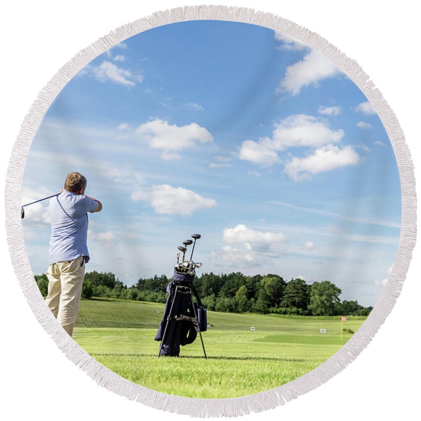 Golf Round Beach Towel featuring the photograph Senior fit man hitting a golf ball. by Michal Bednarek