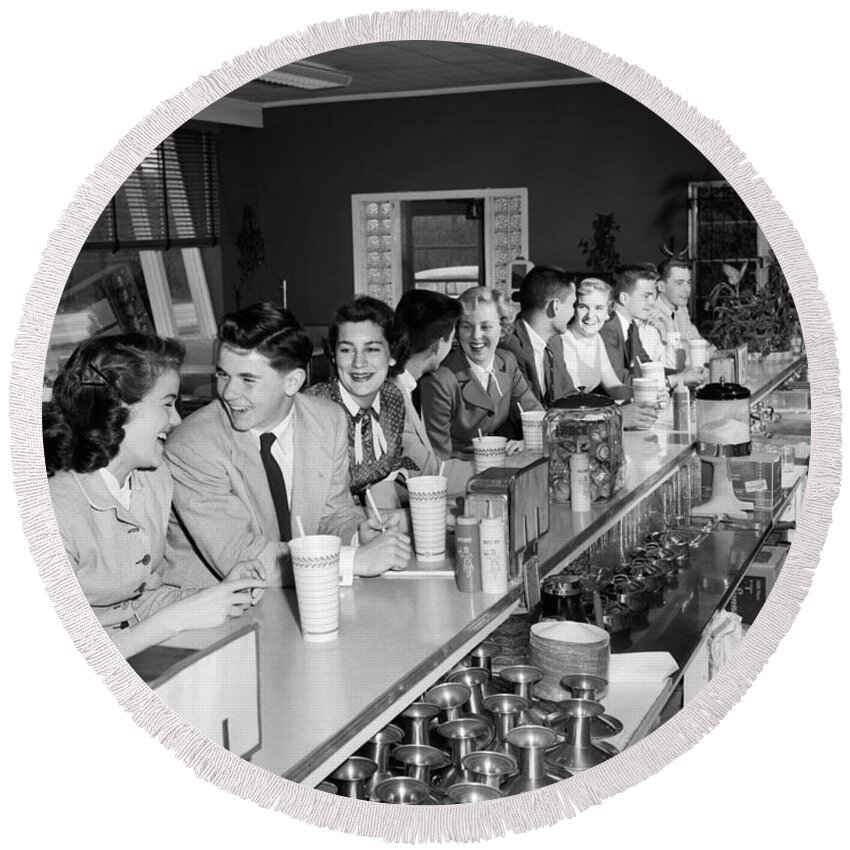 1950s Round Beach Towel featuring the photograph Teens At Soda Fountain Counter, C.1950s by H. Armstrong Roberts/ClassicStock