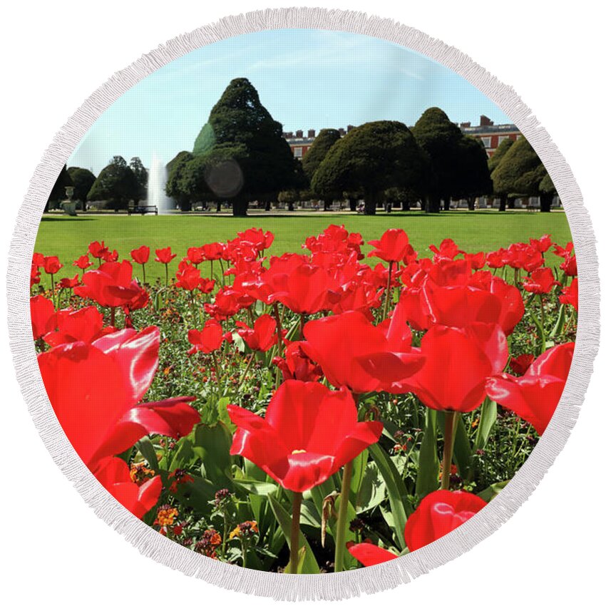 Spring Round Beach Towel featuring the photograph Vibrant Red Tulips at Hampton Court by Julia Gavin