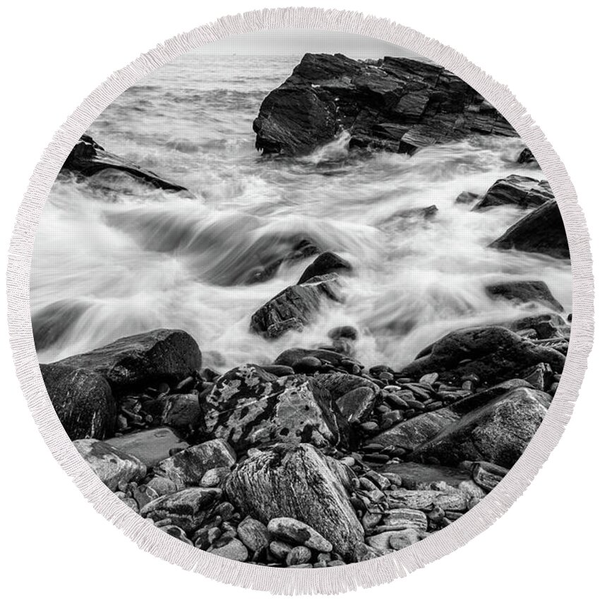 Black And White Round Beach Towel featuring the photograph Waves Against a Rocky Shore in BW by Doug Camara