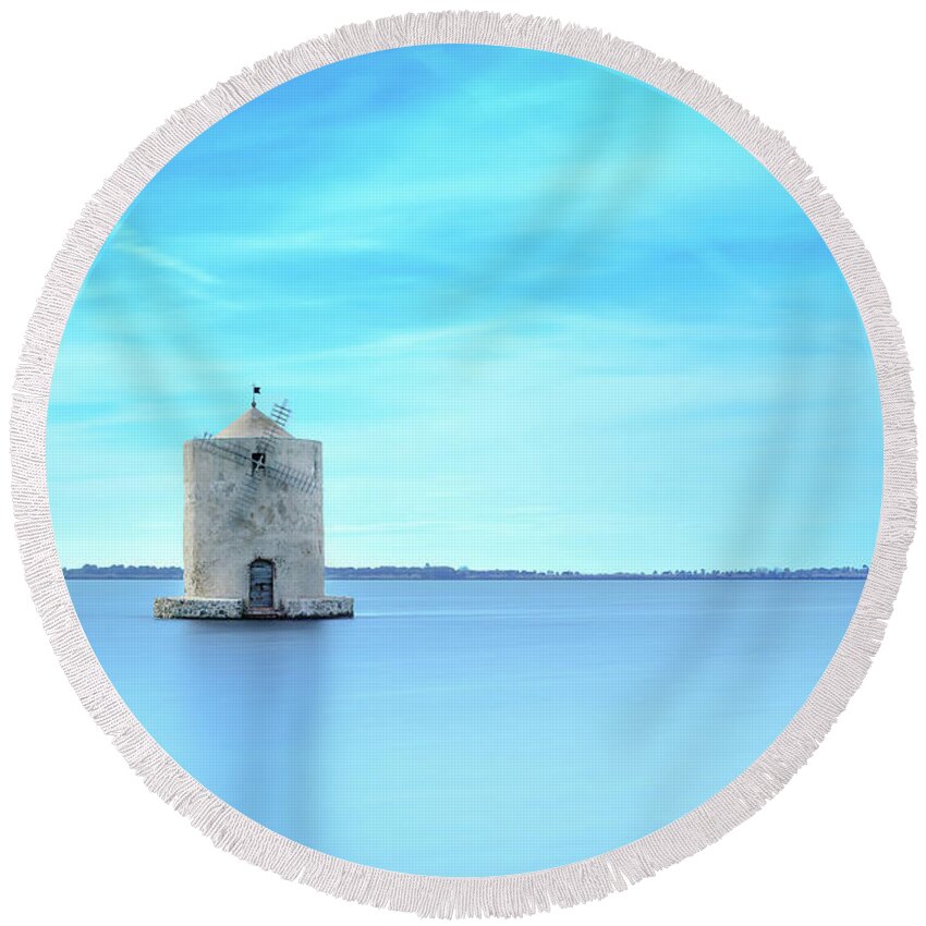 Orbetello Round Beach Towel featuring the photograph Old spanish windmill in a blue lagoon. Orbetello, Argentario, Italy. by Stefano Orazzini