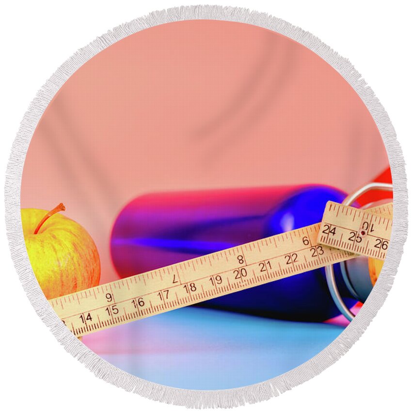 Apple Round Beach Towel featuring the photograph Water bottle, apple and measuring tape isolated on colorful background in studio, healthy life concept. by Joaquin Corbalan