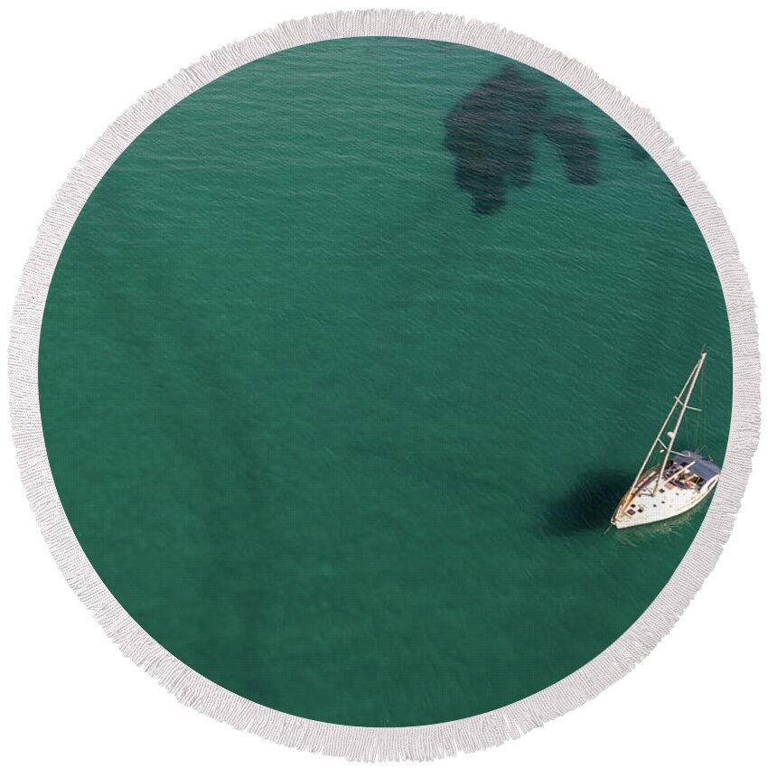 Anchored Round Beach Towel featuring the photograph Aerial view of a luxury yacht anchored in the surface of the sea. Cyprus vacations by Michalakis Ppalis