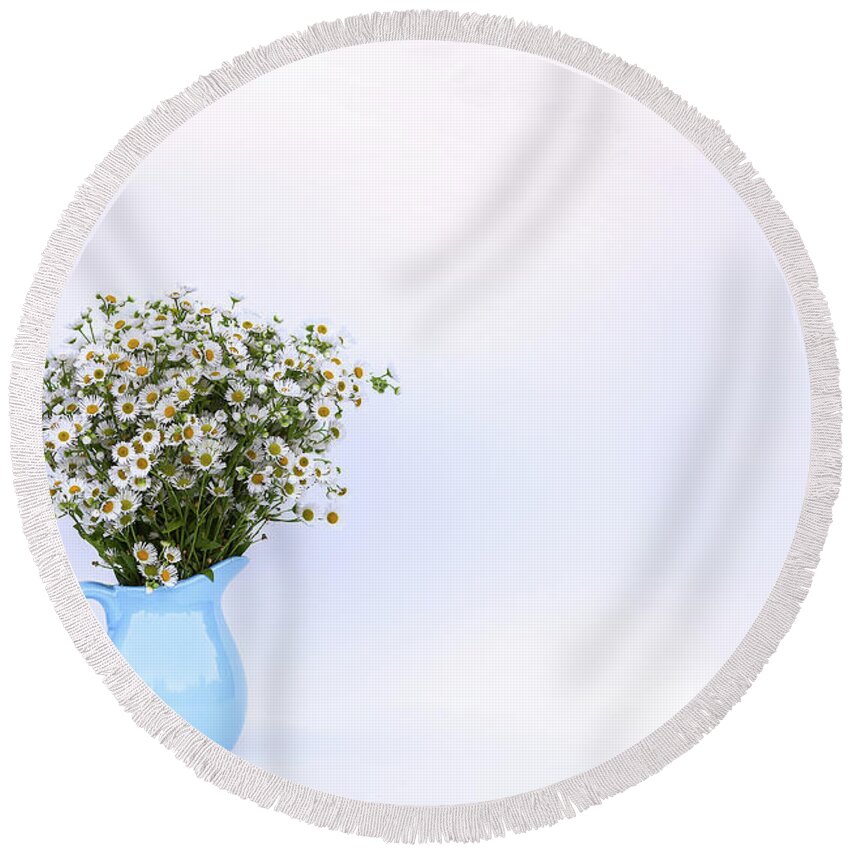 Flower Round Beach Towel featuring the photograph Bouquet of small white daisy flowers in a blue ceramic vase by Olga Strogonova